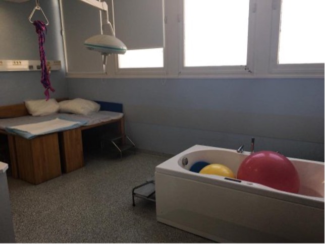 Image d'une salle d'accouchement avec lit, baignoire...
