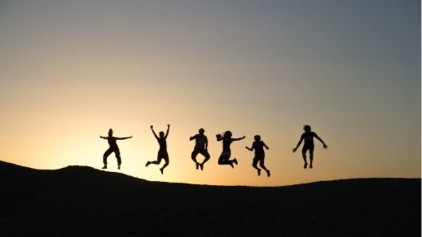 Image de 6 personnes sautant devant un coucher de soleil